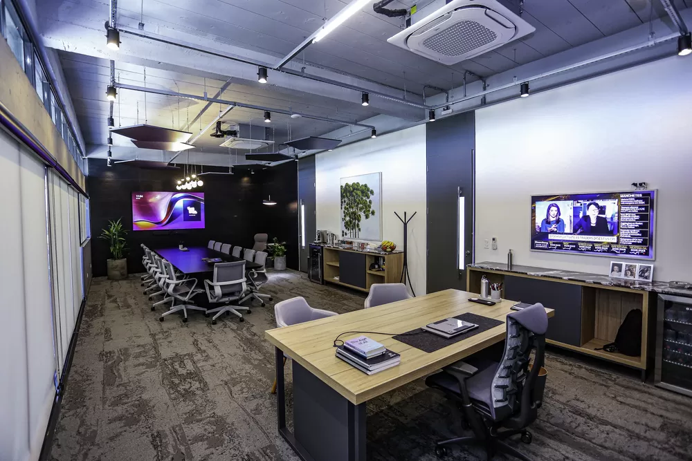 Dois engenheiros, um homem e uma mulher, analisando plantas de um projeto em Curitiba.